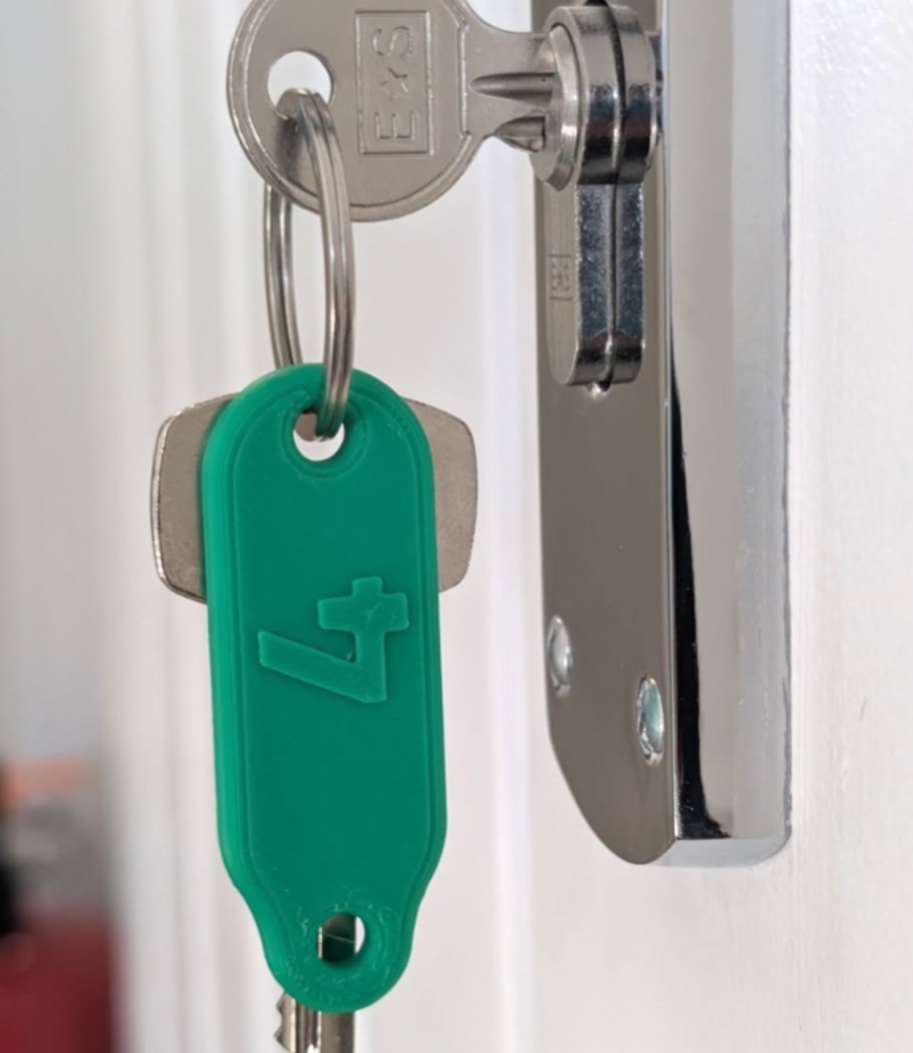 Green 3D printed key turner attached to a door key
