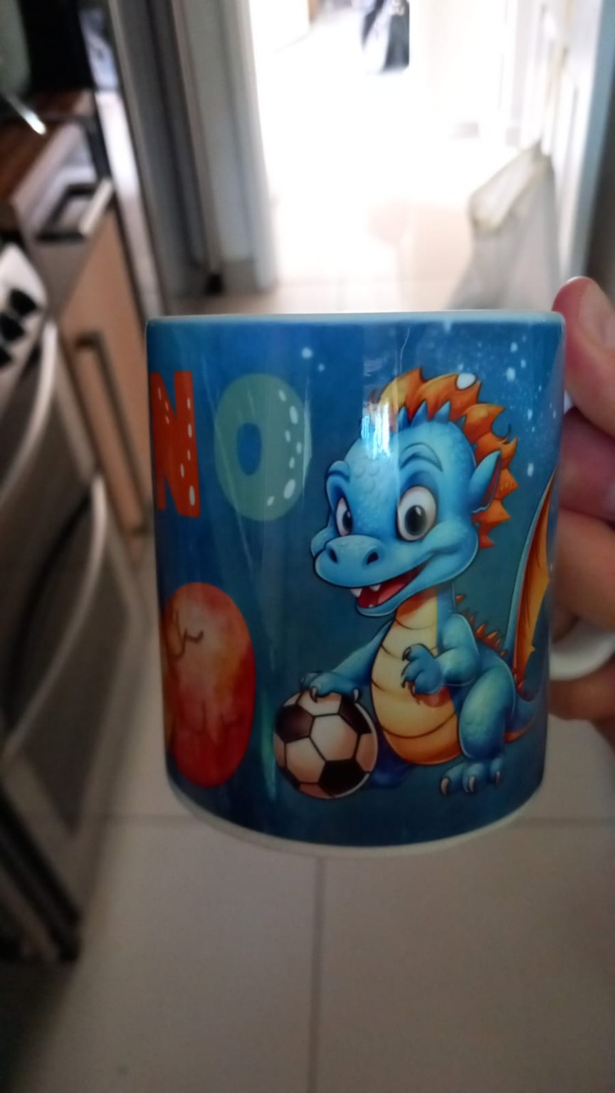 Colourful mug featuring a cartoon dragon with a football