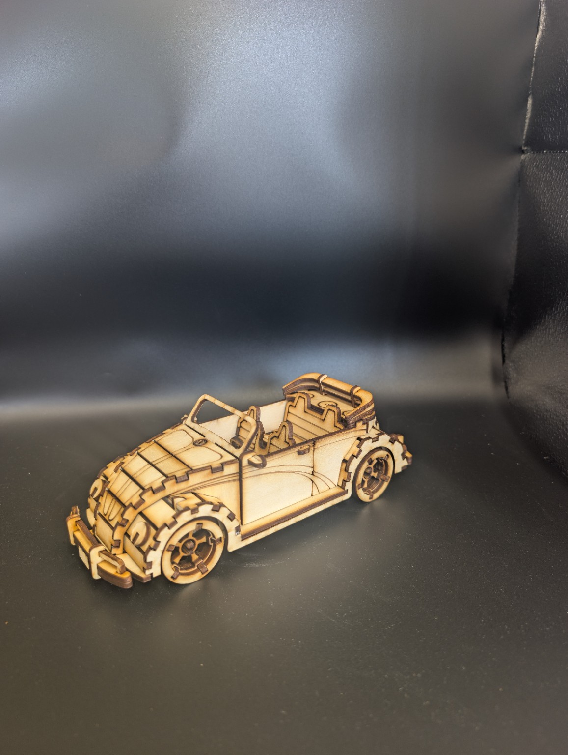 Three-quarter view of a detailed laser-cut wooden classic convertible model