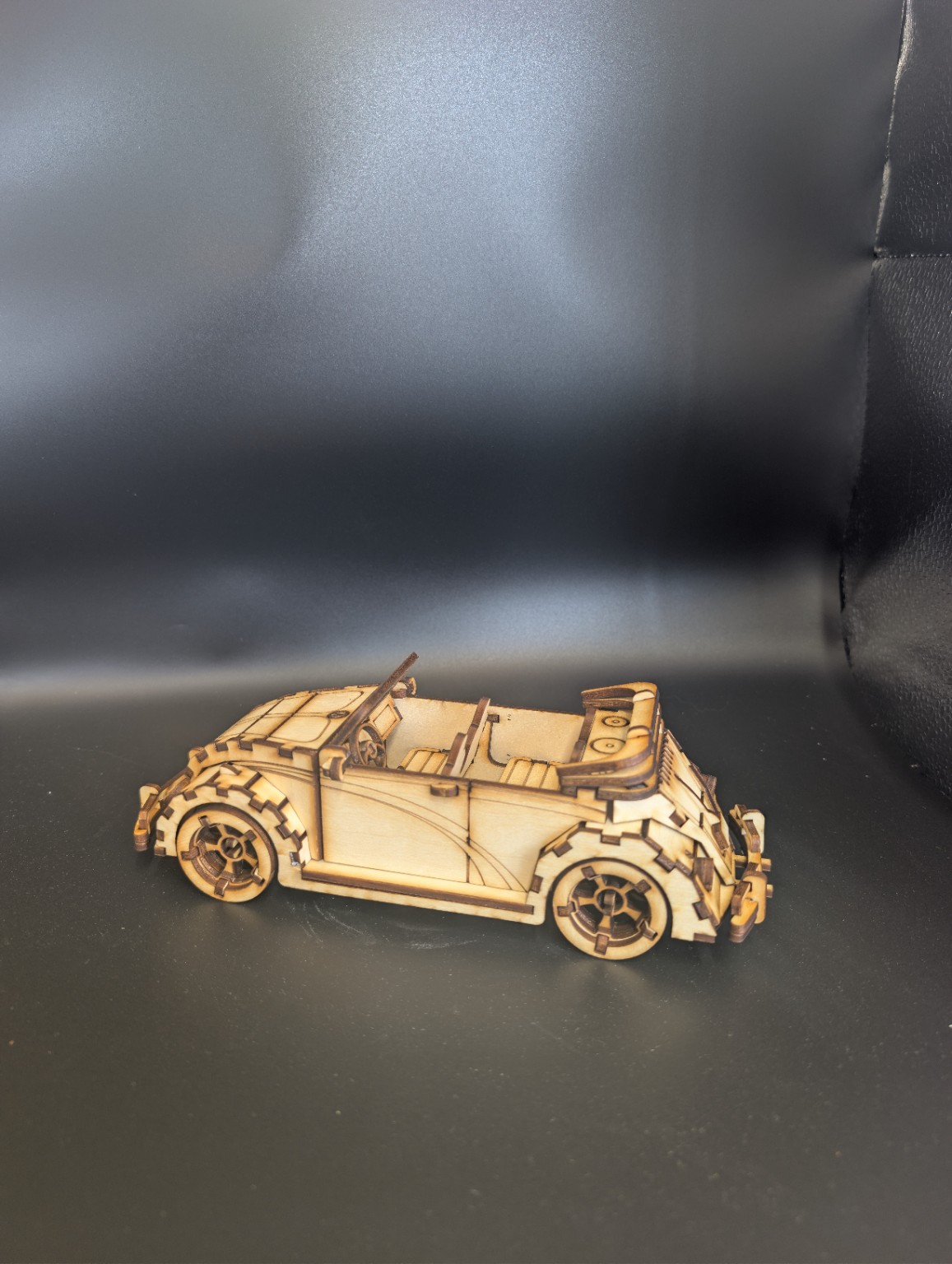 Laser-cut layered wooden classic convertible model viewed from the side